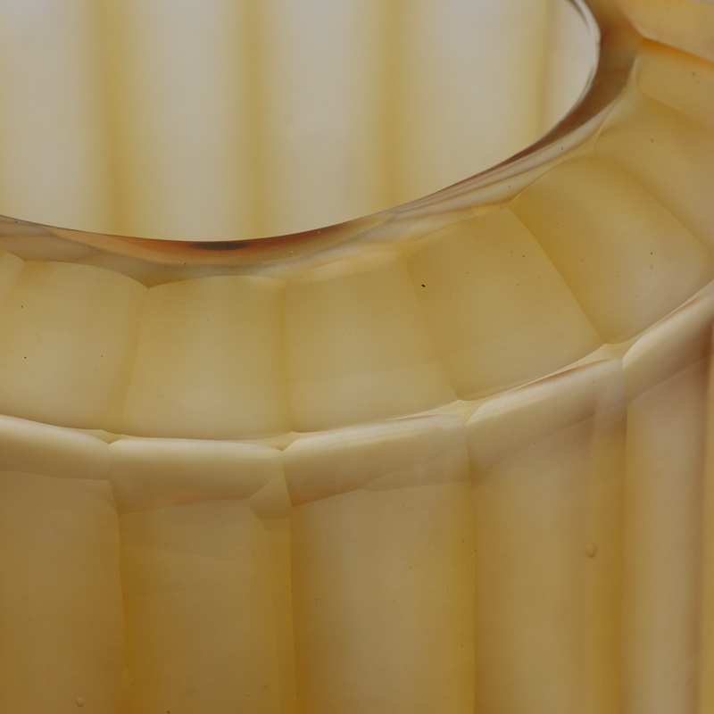 Gouden glazen vaasje met strepen en een ronde vorm